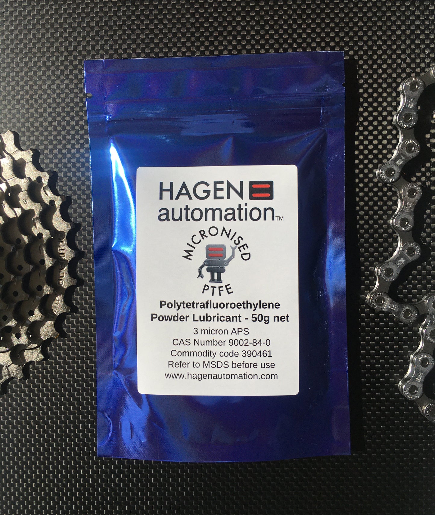 PTFE Powder lubricant 50g Hagen Automation for chain waxing Blue foil pack on carbon fibre with chain and chainring shimano background